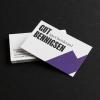 Photo of business card designs for Gut Bennigsen on a black background. The front of the cards is mostly white with a purple geometric shape and the Gut Bennigsen logo in the upper left corner. The back cover is white with info written in black type.
