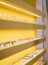 Herr Menig Junior interior retail display in bright yellow with rows of eyeglasses lined up