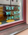 Herr Menig Junior vinyl window signage, photographed from the outside