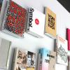 Von and Zu Buch Books of all colors and sizes laid flat and arranged neatly next to each other on a white background