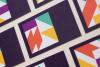 a full-bleed grid of cards, zoomed in, with geometric patterns on a dark purple background. Each card features a bold, abstract design made up of triangles, rectangles, and other shapes in vibrant colors, including orange, yellow, purple, green, and white