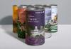 Threes cylindrical packaging designs for "Pure Tea" in various, arranged in a triangle with the flavor "Claire" leading the others in front. All boxes feature an illustrated scenic landscape with theme related to its flavor, showcasing green hills, trees, traditional architecture, mountains, and fauna in the foreground in a flat vector illustration style